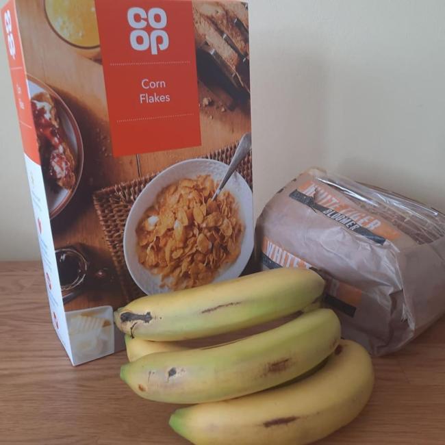 Some bananas, cereal and bread placed on a tabletop