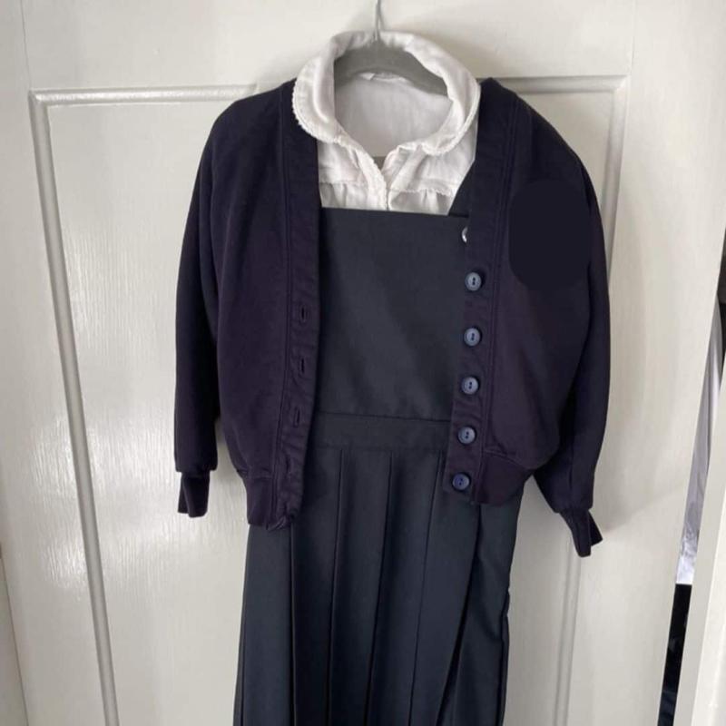 A child's cardigan, polo shirt and dress for school.