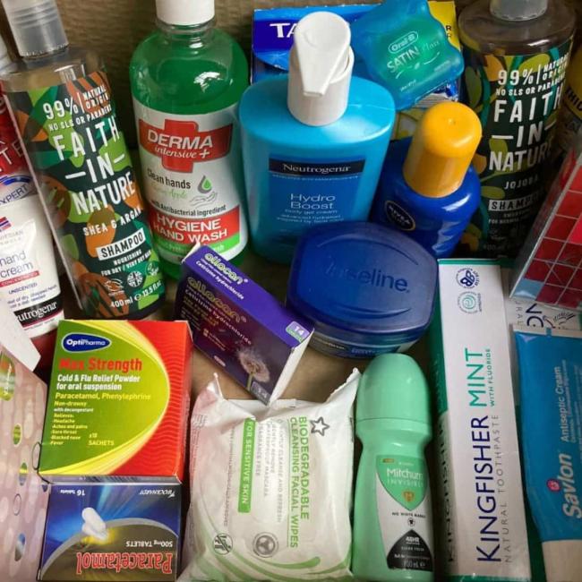 A pile of different hygiene and health items including toothpaste and paracetamol
