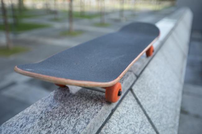 A stationary skateboard resting on a wall 