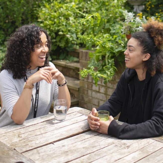 A girl and her practitioner chatting outside