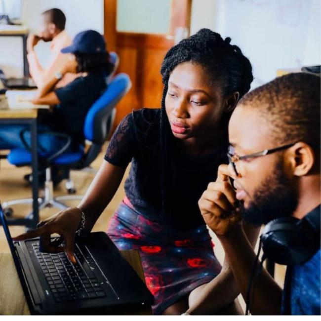 Two teenagers looking working with computers