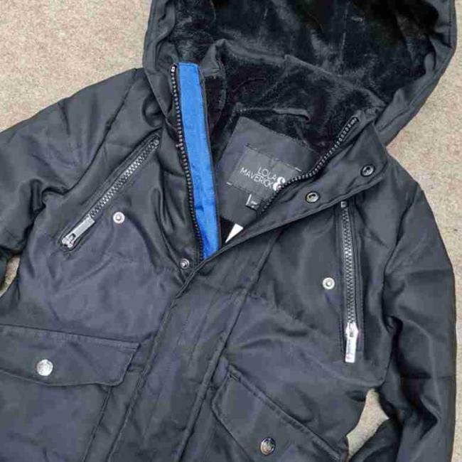 A black childs jacket laid out on the floor.