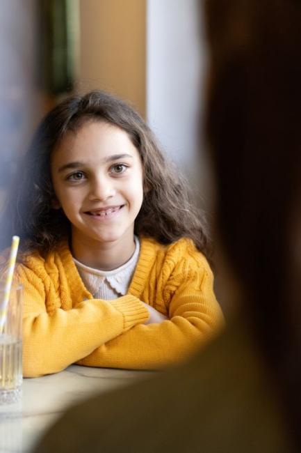 A young girl talking to her therapist and smiling. 