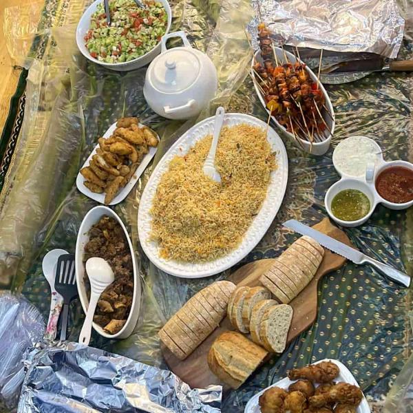 A selection of platters of food laid out on the floor to be eaten during Eid.