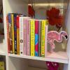 A selection of childrens books placed on a white shelving unit