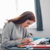 A teenage girl making use of an craft kit on her desk at home