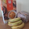 Some bananas, cereal and bread placed on a tabletop