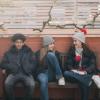Three teenagers relaxing on a park bench