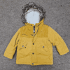 A yellow childs jacket placed on the floor.